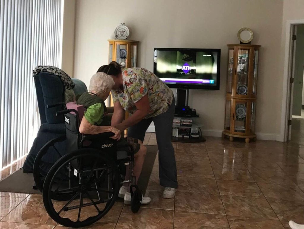 home health worker helping woman in wheelchair